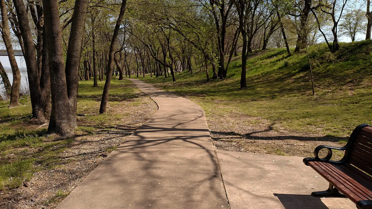 A bench along the walking trail at Fort Smith National Historic Site in Fort Smith, Arkansas (0e886668-1a1f-4d31-8810-705284f42947)