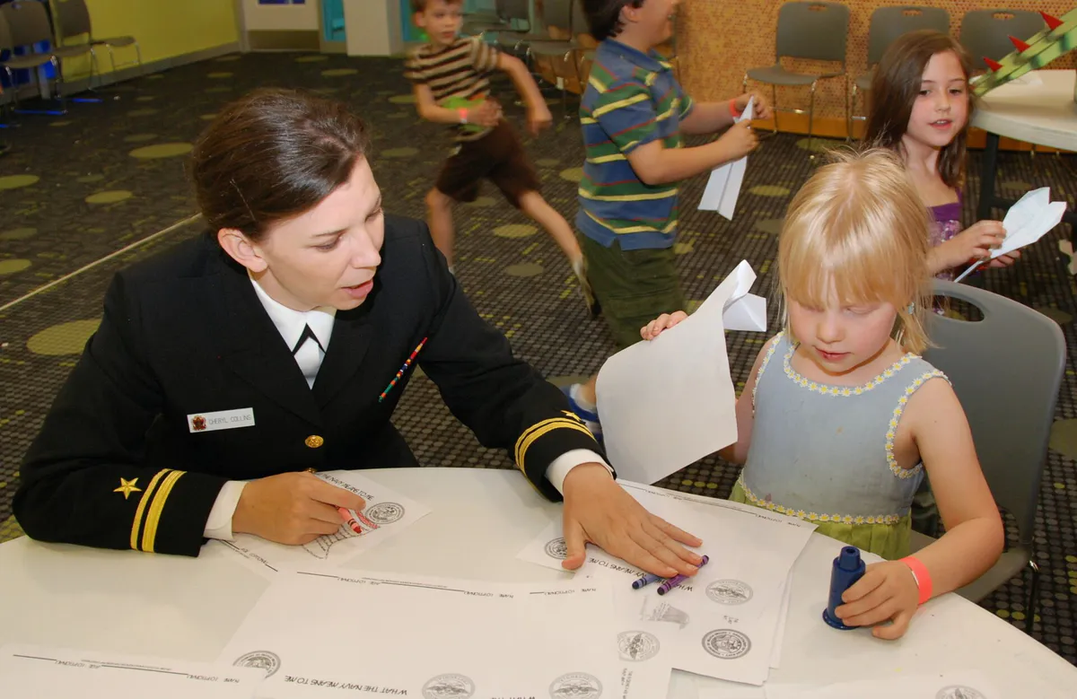 US Navy 110323-N-8750E-117 Lt. J.g. Cheryl Collins, assigned to Navy Community Outreach, helps a child color at the Mississippi Children's Museum d in Jackson, Mississippi