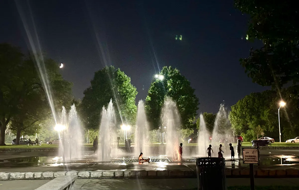 Children play in the Concourse fountains at night, Kessler Park, Kansas City, Missouri